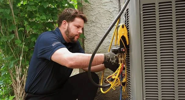 Technician testing an outdoor air conditioner with pressure gauges